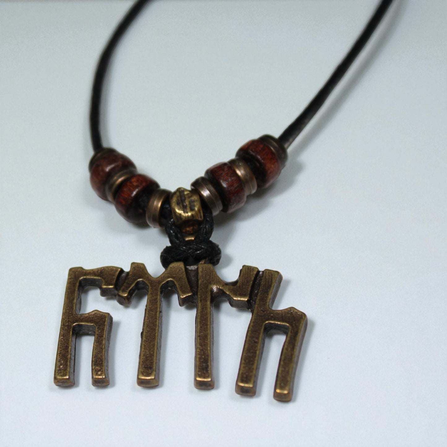 El yapımı kolye, Göktürk alfabesi ile yazılmış "Türk" sözcüğü, zamak metal objeli ve ahşap boncuklu